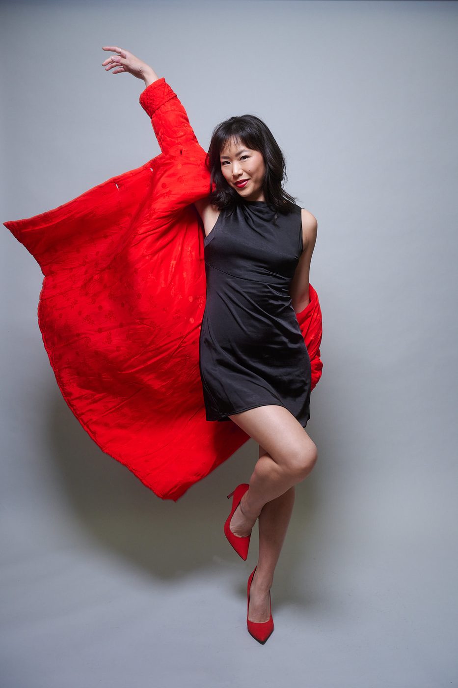 Ashley Chiu, actress and producer, backstage in a red coat